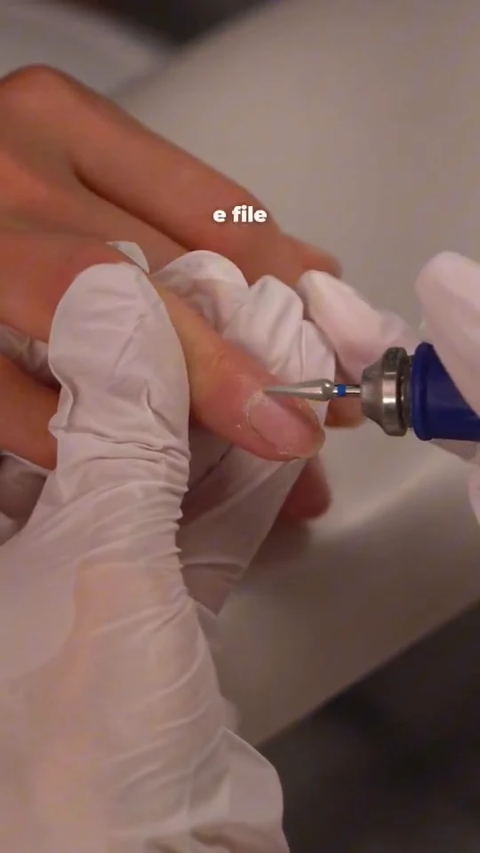 Nail technician performing dry e-file cuticle preparation at M.STUDIO NYC